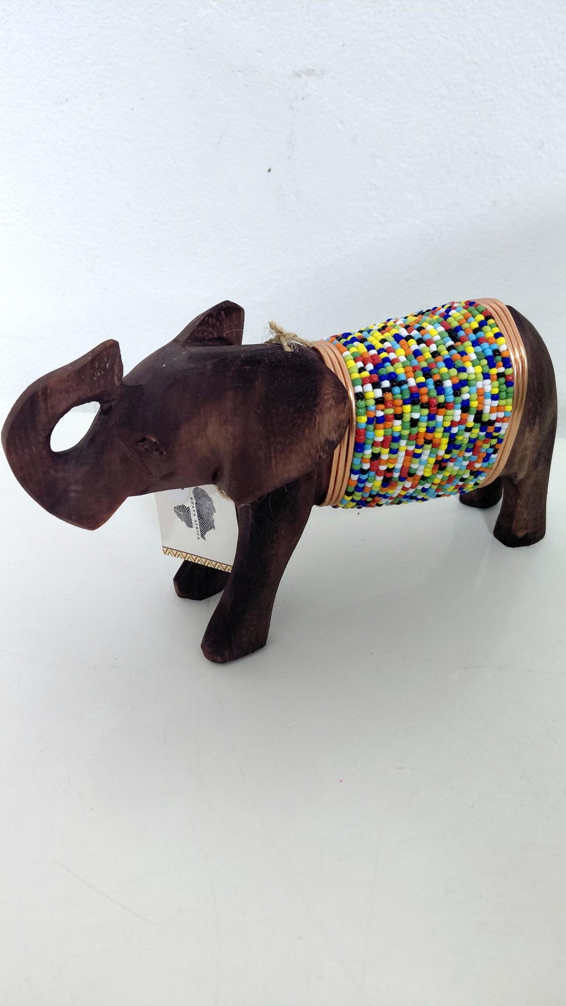 Decorative elephant with a colorful beaded top on a white background